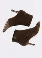 Pair of brown suede high-heeled shoes on a white background