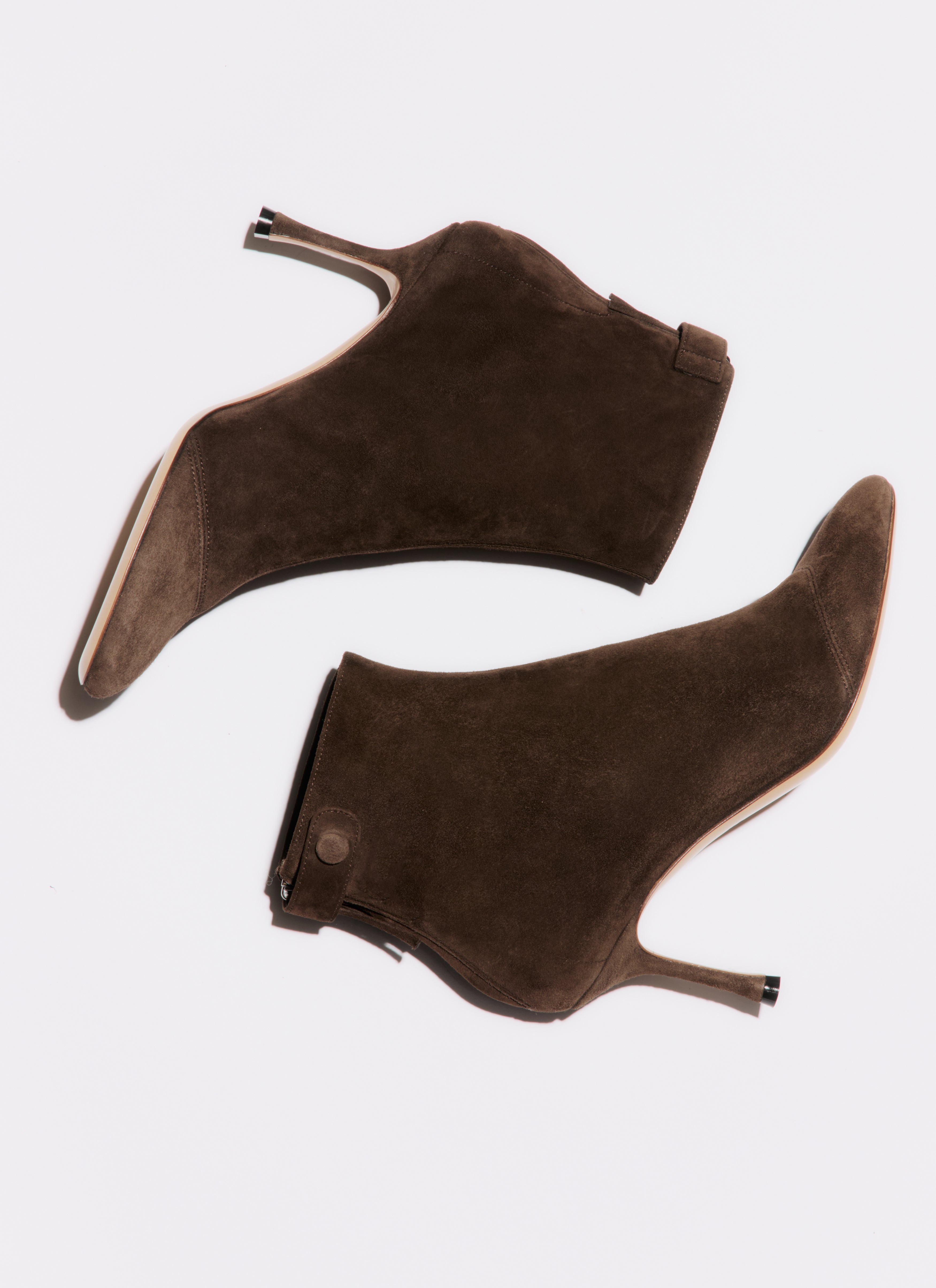 Pair of brown suede high-heeled shoes on a white background