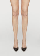 Legs wearing sheer stockings with black high heels on a light gray background